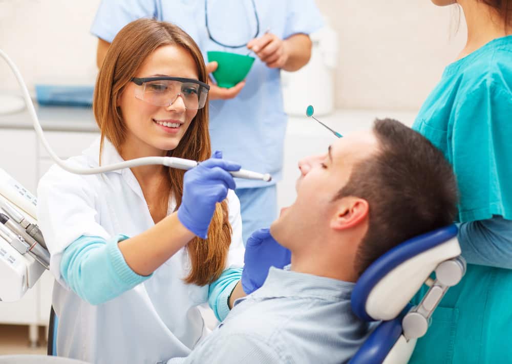 Female Dentists Examining Male Patient
